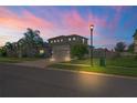 Beautiful two-story home at dusk, featuring a manicured lawn and inviting street lighting at 18558 Cortes Creek Blvd, Spring Hill, FL 34610