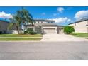 Charming two-story home with three-car garage, landscaped yard and a beautiful palm tree at 18558 Cortes Creek Blvd, Spring Hill, FL 34610