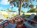 Backyard seating area with brick-lined fire pit and chairs, perfect for outdoor entertaining at 2141 Holiday Dr, Holiday, FL 34691
