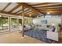 Bright and airy living room with exposed beam ceiling, modern furniture, and large sliding doors at 34577 Orchid Pkwy, Dade City, FL 33523