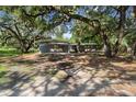 Single story house with covered carport and large yard with mature trees at 34577 Orchid Pkwy, Dade City, FL 33523