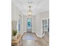 Inviting foyer with decorative lighting, light grey walls, and a modern front door with a wreath at 3885 Villamore Ln, Odessa, FL 33556