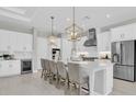 Bright and airy kitchen featuring a large center island, pendant lighting, and stainless steel appliances at 4026 Bonfire Dr, Odessa, FL 33556