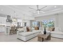 Open-concept living room with a large sofa, ceiling fan and easy access to the gourmet kitchen at 4026 Bonfire Dr, Odessa, FL 33556