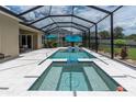 Relaxing screened-in pool area with in-pool seating and umbrella, perfect for enjoying outdoor living at 4026 Bonfire Dr, Odessa, FL 33556
