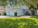 Lovely exterior with a three car garage, lush green lawn, and meticulously landscaped grounds at 4481 Birchfield Loop, Spring Hill, FL 34609