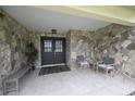 Inviting front porch with stone accents, tiled floor, and seating perfect for enjoying the outdoors at 4702 Portland Manor Dr, New Port Richey, FL 34655