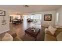 Open-concept living room featuring wood-look floors, neutral tones, and seamless flow to dining and kitchen areas at 4702 Portland Manor Dr, New Port Richey, FL 34655