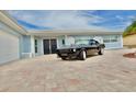 Exterior angle view of blue home with a classic black car sitting in the front of the house at 5339 Bowline Bnd, New Port Richey, FL 34652