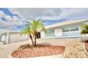Angle view of blue home with well maintained landscaping, stone and mulch and a two-car garage at 5339 Bowline Bnd, New Port Richey, FL 34652
