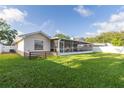 Spacious, fully fenced backyard with lush lawn and screened-in lanai perfect for outdoor entertaining at 5520 Fulmar Dr, Tampa, FL 33625