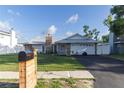 Beautiful single-story house with well-manicured lawn, stone chimney, metal roof, and black mailbox on a wooden post at 5520 Fulmar Dr, Tampa, FL 33625