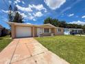Inviting single-Gathering home with manicured lawn, charming facade, and attached garage on a sunny day at 6341 Hyperion Dr, Port Richey, FL 34668