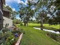 Serene backyard with lush lawn, mature trees, and a tranquil creek at 7135 Trenton Pl, New Port Richey, FL 34653
