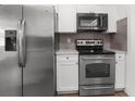 Well-equipped kitchen with stainless steel appliances, white cabinets, and countertops at 7192 Catalina St, Spring Hill, FL 34606