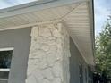Unique stone accent wall feature, seamlessly blending texture and style with a neutral trim and siding at 723 W Bayshore Dr, Tarpon Springs, FL 34689