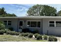Well-maintained gray home with a charming front entry, lush landscaping, and ample natural light at 723 W Bayshore Dr, Tarpon Springs, FL 34689
