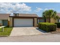 Attractive home with a spacious driveway and a verdant bush, perfect for a Gathering, complemented by a well-maintained lawn at 7412 Bellows Falls Ln, Hudson, FL 34667