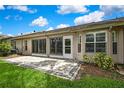 The home features a charming, open back patio with sliding glass doors leading into the home and manicured lawn at 7423 Woodhollow Rd, Spring Hill, FL 34606