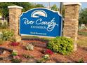 Decorative community sign reading 'River Country Estates' with colorful landscaping at 7550 Jomel Dr, Weeki Wachee, FL 34607