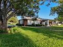 Attractive single-story home featuring mature trees, lush green lawn, and meticulously maintained landscaping at 8130 Bugle Ct # 3, Port Richey, FL 34668