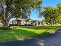 Inviting single-story home with fresh green lawn, large shade trees, and neatly trimmed landscaping at 8130 Bugle Ct # 3, Port Richey, FL 34668