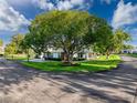 This property features a single-story home surrounded by mature trees and landscaping, situated on a corner lot at 8130 Bugle Ct # 3, Port Richey, FL 34668