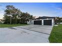 Contemporary home featuring a spacious driveway, well-maintained lawn, and a modern two-car garage at 9201 Nightingale Rd, Weeki Wachee, FL 34613
