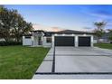 Stunning contemporary home featuring a manicured lawn, wide driveway, and a stylish two-car garage at 9201 Nightingale Rd, Weeki Wachee, FL 34613