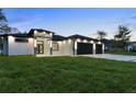 Elegant home featuring a modern design, manicured lawn, and a welcoming entrance at 9201 Nightingale Rd, Weeki Wachee, FL 34613