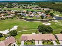 Beautiful aerial view of the community golf course, surrounding ponds, and a few houses with pools at 1009 Almondwood Dr, Trinity, FL 34655
