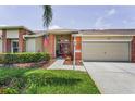 Charming single-story home with a red front door, well-manicured lawn, and an attached two-car garage at 1009 Almondwood Dr, Trinity, FL 34655
