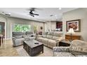 Open-concept living room with large windows, tile flooring, and comfortable seating at 11101 Ragsdale Ct, New Port Richey, FL 34654