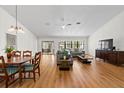 Bright open-plan living and dining area featuring hardwood floors and sliding doors at 11621 Pear Tree Dr, New Port Richey, FL 34654