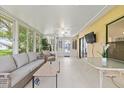 Enclosed sunroom bathed in natural light with tile flooring and comfortable seating at 11621 Pear Tree Dr, New Port Richey, FL 34654