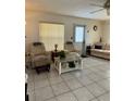 Bright living room with neutral tile flooring, large windows, and comfortable seating at 12104 Boynton Ln, New Port Richey, FL 34654