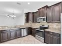 Modern kitchen with stainless steel appliances, granite countertops, and dark cabinetry, perfect for cooking and entertaining at 13600 Crest Lake Dr, Hudson, FL 34669