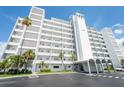 A full exterior view of the condo building with palm trees, manicured landscaping and circular decorative patterns at 1365 Snell Isle Ne Blvd # 1B, St Petersburg, FL 33704