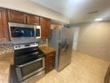 Kitchen featuring stainless steel appliances, tile backsplash, granite countertops and tile flooring at 1392 Piper Rd, Spring Hill, FL 34606