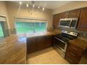 Cozy kitchen featuring stainless steel appliances, granite counters, mosaic tile backsplash, and a window over the sink at 1392 Piper Rd, Spring Hill, FL 34606