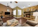 Cozy living room with stone fireplace, wood floors, and a ceiling fan for added comfort at 1430 Rosetree Ct, Clearwater, FL 33764