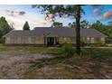 Serene single-story home with a lush front yard, beautiful twilight sky, and well-lit facade at 14645 Spellman Ct, Spring Hill, FL 34610