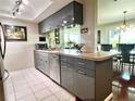 Modern kitchen with sleek cabinetry, stainless steel appliances, and a view into the dining area at 3447 Paloma Dr, Holiday, FL 34690
