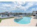 Backyard pool and jacuzzi overlooking water with a boat lift and dock at 3701 Corsair Ct, New Port Richey, FL 34652