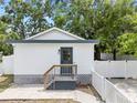 The exterior of the back house has white siding, a dark gray trim, small porch, with white picket fences on both sides at 4622 Paloverde Dr, New Port Richey, FL 34652