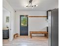 The interior boasts modern lighting, wooden floors, bench, and a stylish door that invites natural light at 4622 Paloverde Dr, New Port Richey, FL 34652