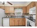This classic kitchen features wooden cabinets, tile backsplash and modern appliances at 6702 Dartmoor Ln # 7A, New Port Richey, FL 34653