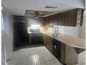 Well-lit kitchen featuring ample counter space, wood cabinetry, and modern black appliances at 7338 Foxbloom Dr, Port Richey, FL 34668