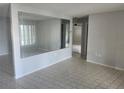 Bright living room with large mirror, tile flooring, and a view into other rooms at 7338 Foxbloom Dr, Port Richey, FL 34668