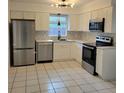 Modern kitchen featuring stainless steel appliances and white cabinetry at 8504 Lafitte Dr, Hudson, FL 34667